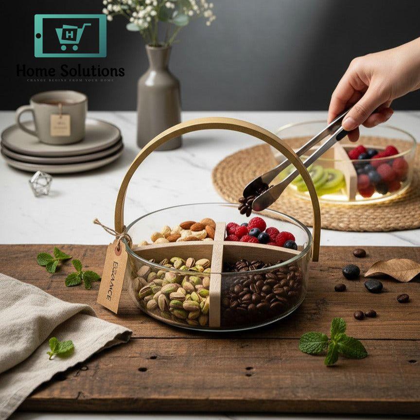 Glass snack tray with compartments filled with nuts and berries on a wooden surface.