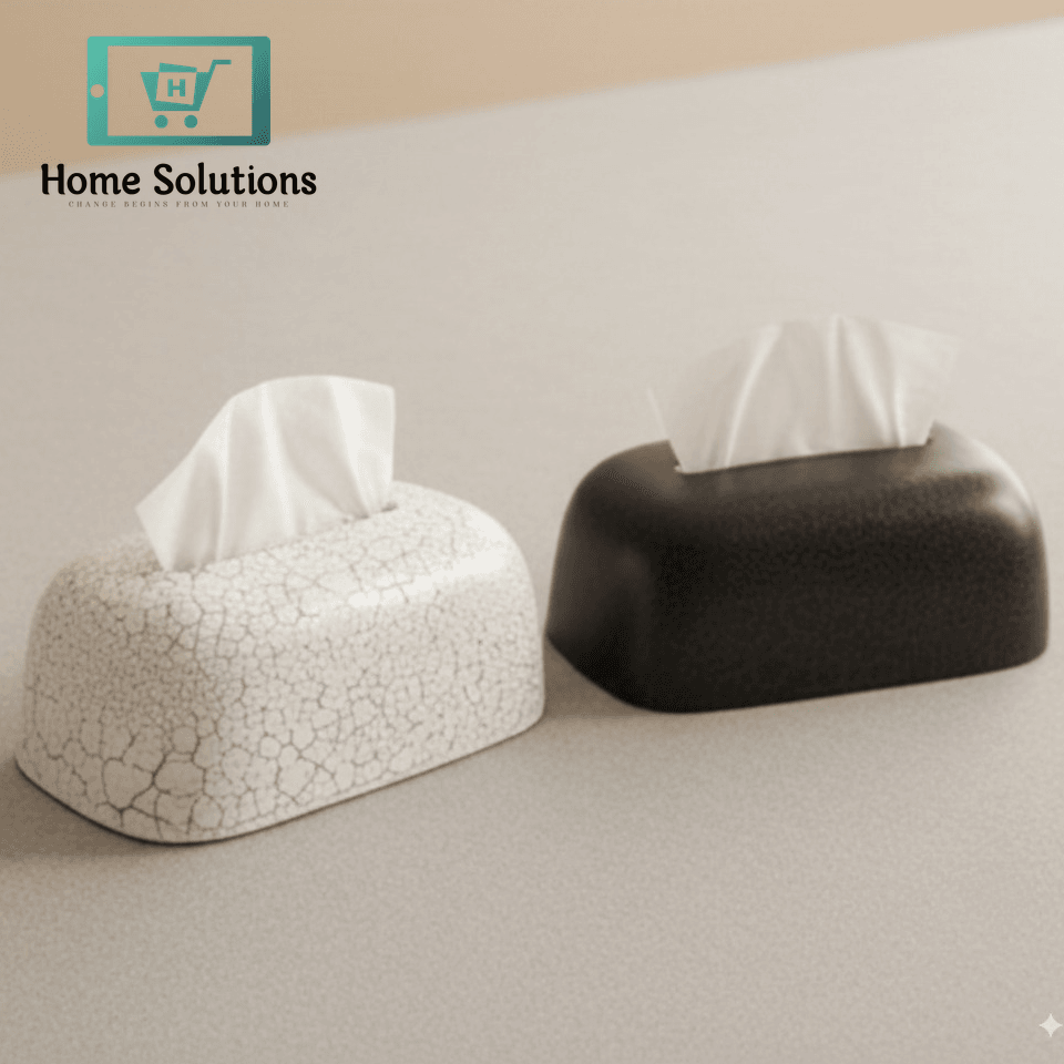 Two tissue boxes, one white and one black, on a light surface.