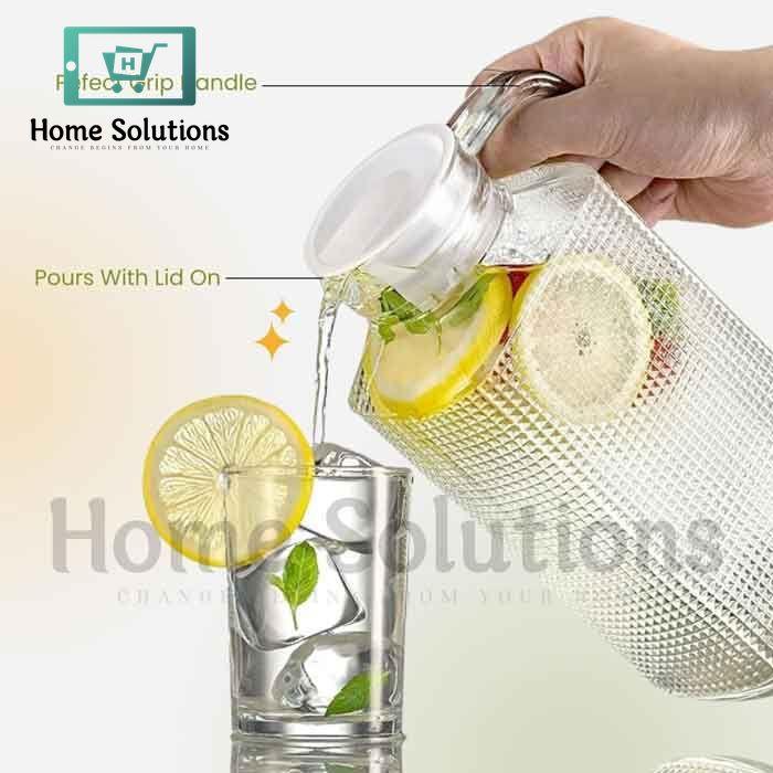Glass pitcher with lemon slices being poured into a glass, with 'Home Solutions' branding.