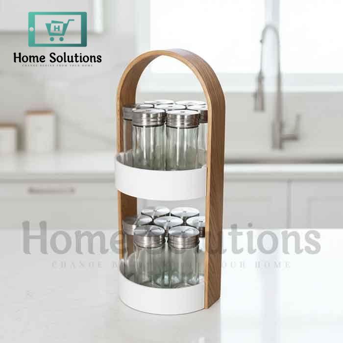 Wooden two-tier spice rack for Pakistani kitchen with 12 glass jars and stainless steel lids, showing modern countertop organization.

