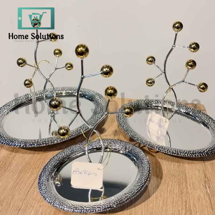 Decorative Oval trays with metallic branches and spherical ends on a wooden surface.