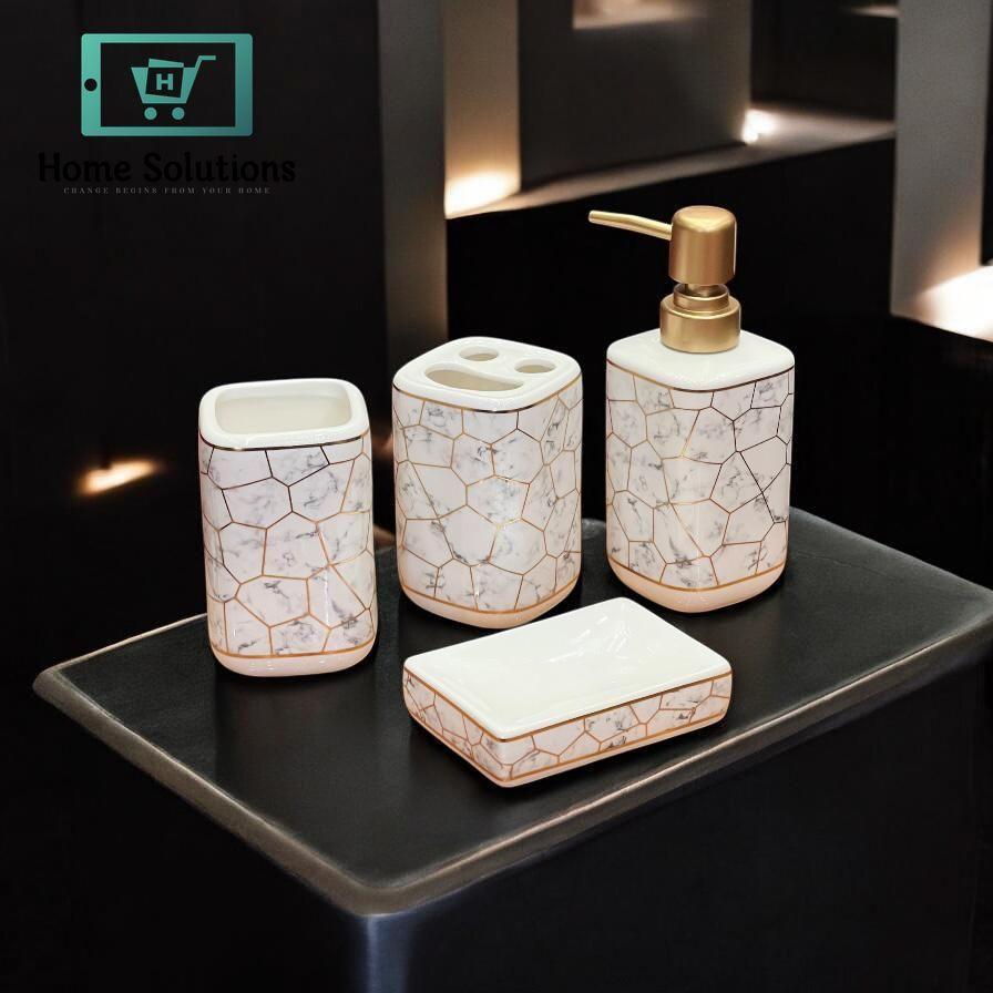 Bathroom accessory set with marble pattern on a dark surface, featuring Home Solutions branding.