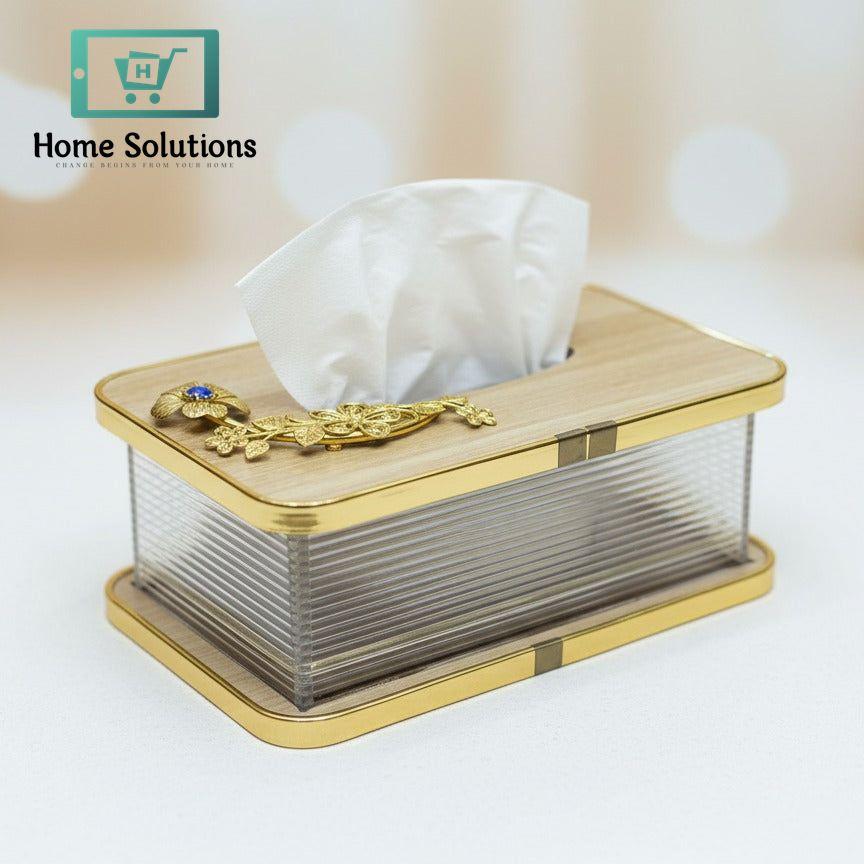Tissue box with gold accents on a light background
