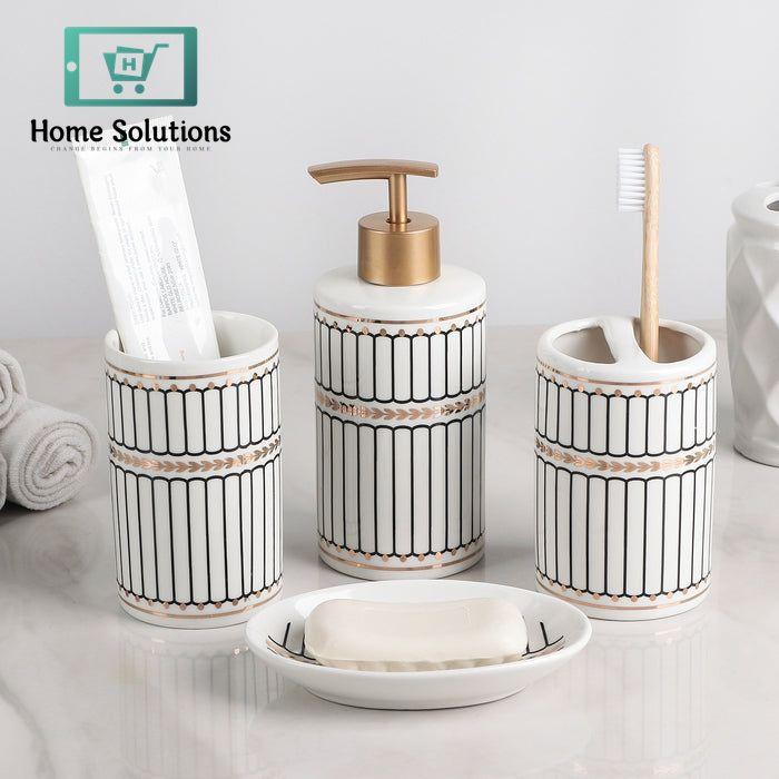 Bathroom accessory set with containers, a soap dispenser, and a dish on a light surface.