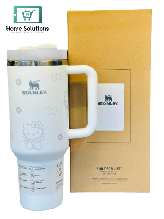 White Stanley tumbler with Hello Kitty design next to a matching box on a reflective surface.