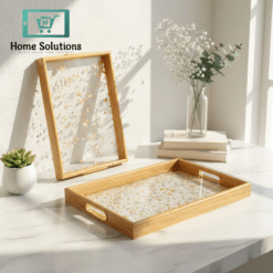 Wooden tray with decorative interior on a marble surface with a framed picture and plant in the background.