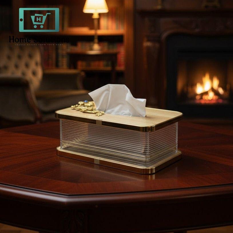 Premium Wood Top Gilded Tissue Box with Metal Motif 4 Tissue box on a wooden table with a cozy room background featuring a bookshelf and fireplace.