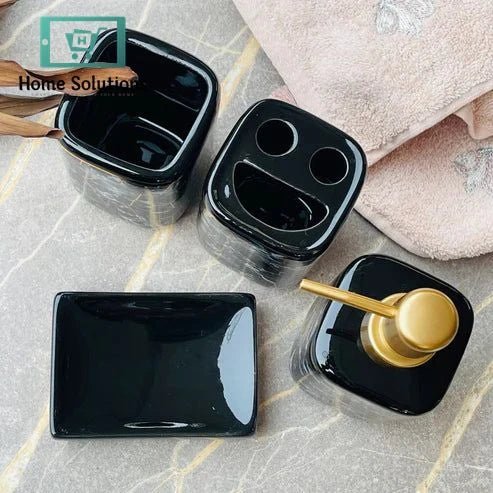 Marble Black Bathroom Accessory Set – 4 Piece Collection 4 Set of black ceramic containers with a gold pump on a marble surface.