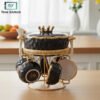 Black ceramic soup set with golden stand and handles, displayed on glass shelf — luxury soup serving set 16 pcs.